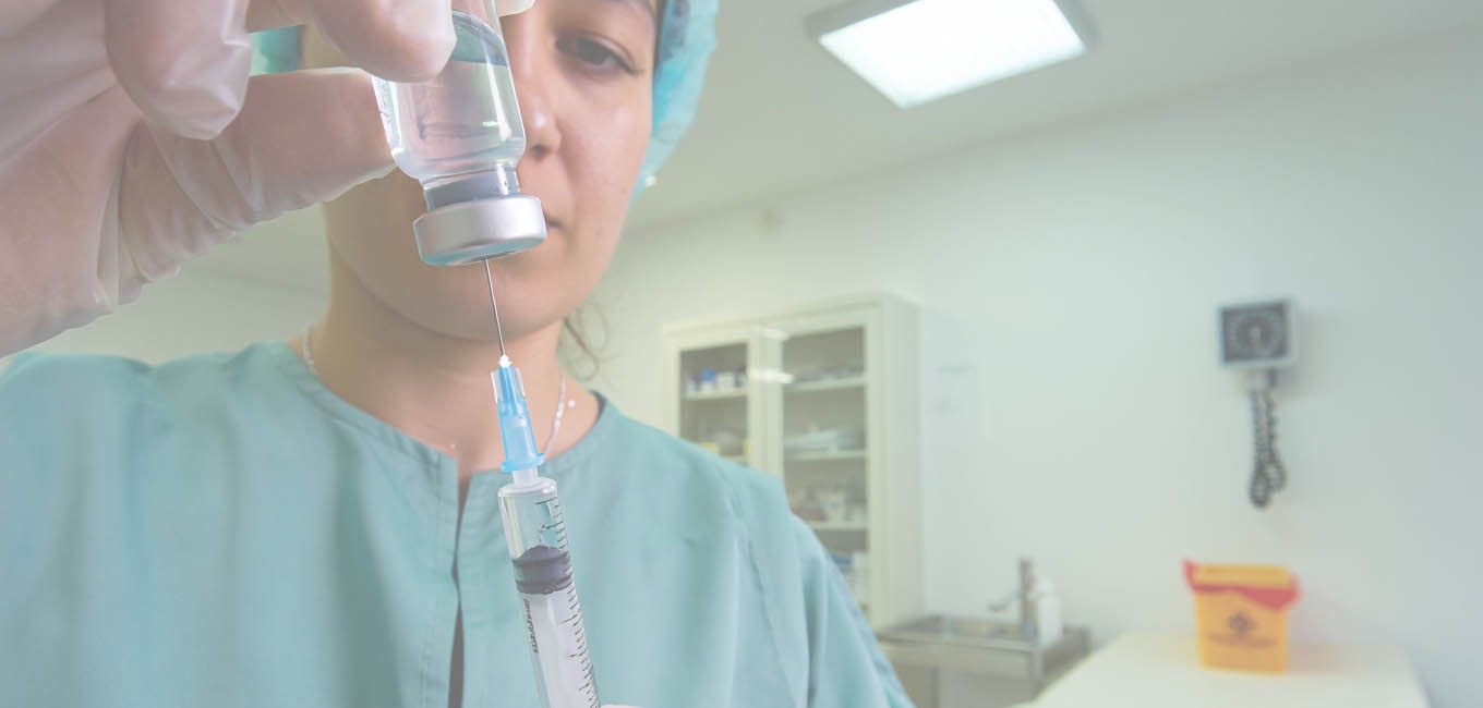 Женщина-врач аккуратно заливает лекарство в шприц